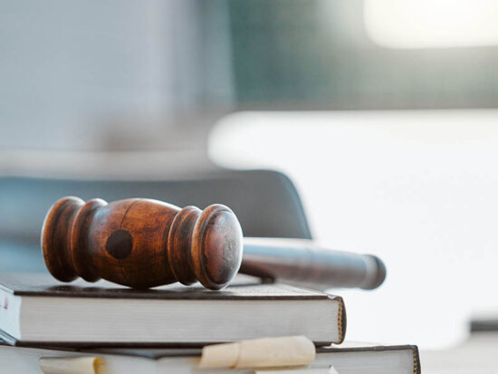 Justice, gavel and law books on table in office for court trial, legislation or fair constitution by judicial system. Firm, closeup and legal hammer by information for corporate case in workplace.